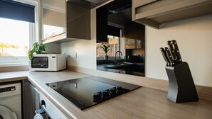 Una cocina moderna con microondas integrado, estufa y bloque de cuchillos.