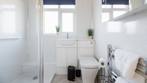 Un baño moderno con ducha, inodoro y lavabo.