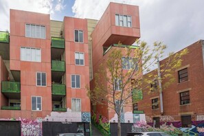 A multi-story building with balconies, a tree in front, and graffiti on the walls. - Garnet Gallery A Vintage Stay near Dining and Museum (Fitzroy)