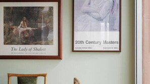 Un comedor con una mesa y sillas de madera, una obra de arte en la pared y un ventanal con vistas.