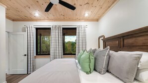 Una camera da letto con un letto, tende e vista dalla finestra.