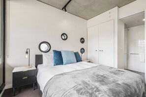 Ein modernes Schlafzimmer mit einem Bett, Nachttischen und einem Kleiderschrank.