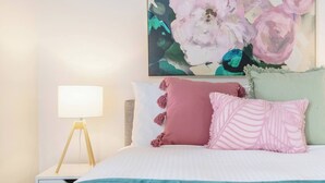 A bedroom with a bed, a bedside lamp, and a large floral artwork on the wall. - Southbank Vista Modern Retreat with Pool and Rooftop (Southbank)