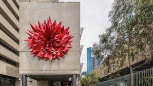 A modern building with a large red geometric sculpture on the facade. - Southbank Vista Modern Retreat with Pool and Rooftop (Southbank)