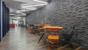 A modern interior with a brick wall, wooden flooring, and orange chairs around a table. - Southbank Vista Modern Retreat with Pool and Rooftop (Southbank)
