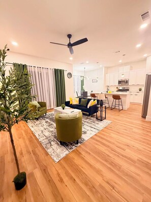 Ein modernes Wohnzimmer mit einer Couch, einem Couchtisch und einem Essbereich mit Stühlen.