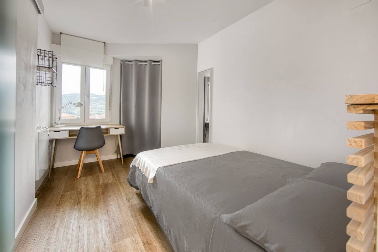 Une chambre à coucher avec un lit, un bureau et une chaise.