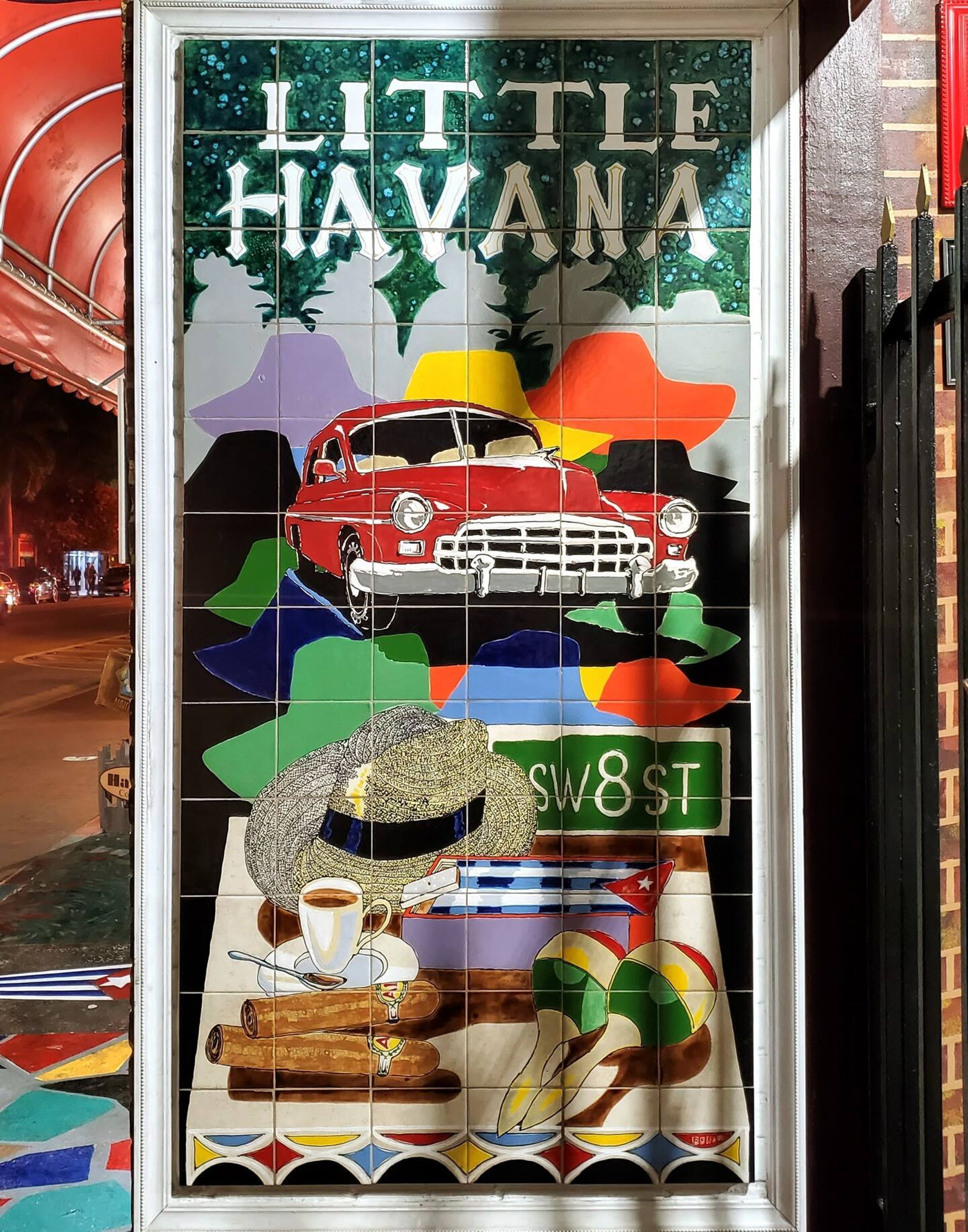 Une vitrine aux couleurs vives, avec une voiture ancienne, un chapeau et une tasse de café.
