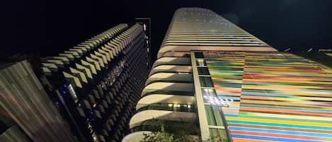 A modern building with a unique curved facade and a colorful striped pattern on one side.