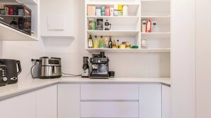 Een moderne keuken met een ingebouwde koffiecorner, een broodrooster en een koffiezetapparaat.