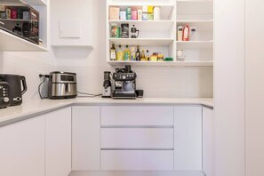 A modern kitchen with a built-in coffee station, a toaster, and a coffee maker. - Raleigh Escape Urban Comfort near Albert Park Lake (Windsor)
