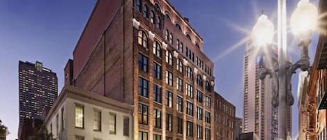 A multi-story building with a classic architectural design, featuring a prominent corner entrance and large windows.