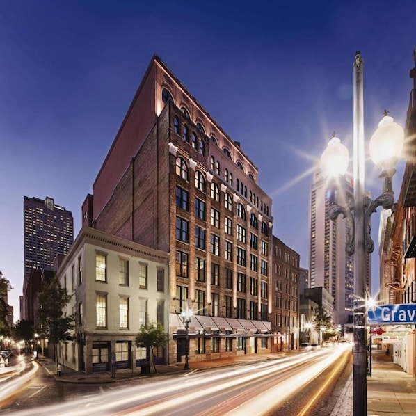 A multi-story building with a classic architectural design, featuring a prominent corner entrance and large windows.