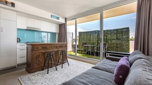 A modern apartment with a kitchen, dining area, and a balcony with a view. - Hampton Beach Nook Simple Stay near Dining and Beach (Hampton)