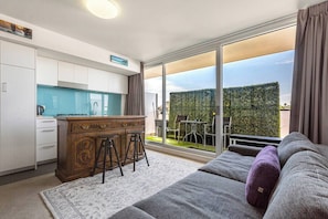 A modern apartment with a kitchen, dining area, and a balcony with a view. - Hampton Beach Nook Simple Stay near Dining and Beach (Hampton)
