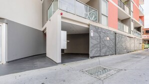 A multi-story residential building with a covered entrance, a bicycle parked on the balcony, and a gated parking area. - Hampton Beach Nook Simple Stay near Dining and Beach (Hampton)