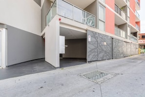 A multi-story residential building with a covered entrance, a bicycle parked on the balcony, and a gated parking area. - Hampton Beach Nook Simple Stay near Dining and Beach (Hampton)
