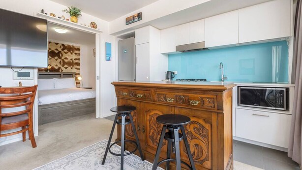 A compact hotel room with a kitchenette, a bed, a desk, and a small bar area. - Hampton Beach Nook Simple Stay near Dining and Beach (Hampton)
