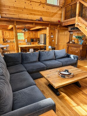Ein modernes Blockhaus-Interieur mit einer Eckcouch, einem Holztisch und einer Küchenzeile.