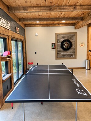 Ein Tischtennisplatte mit 'EASTPOINT'-Branding, eine Dartscheibe und eine weitere Dartscheibe mit Zielscheibe.