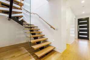 Eine moderne Treppe mit Holzboden und Glasgeländern.