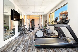 A hotel gym with treadmills, dumbbells, and exercise equipment.