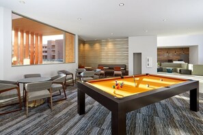 A modern room with a pool table, seating area, and large windows. - Moab | Adventure Desert Retreat | Pool + Hot Tub (Moab)