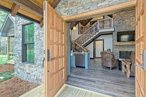 Ein geräumiges Interieur mit Steinwand, einer Holztreppe und einem Kamin.