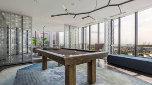 A modern indoor pool table with a city view, a seating area, and a decorative ceiling. - Mariner Resort Style Escape Where City meets Coast (Port Melbourne)