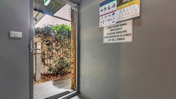 A door with a security sign, a recycling guide, and a vent. - Tullo Place Richmond Heritage with Artistic Charm (Richmond)