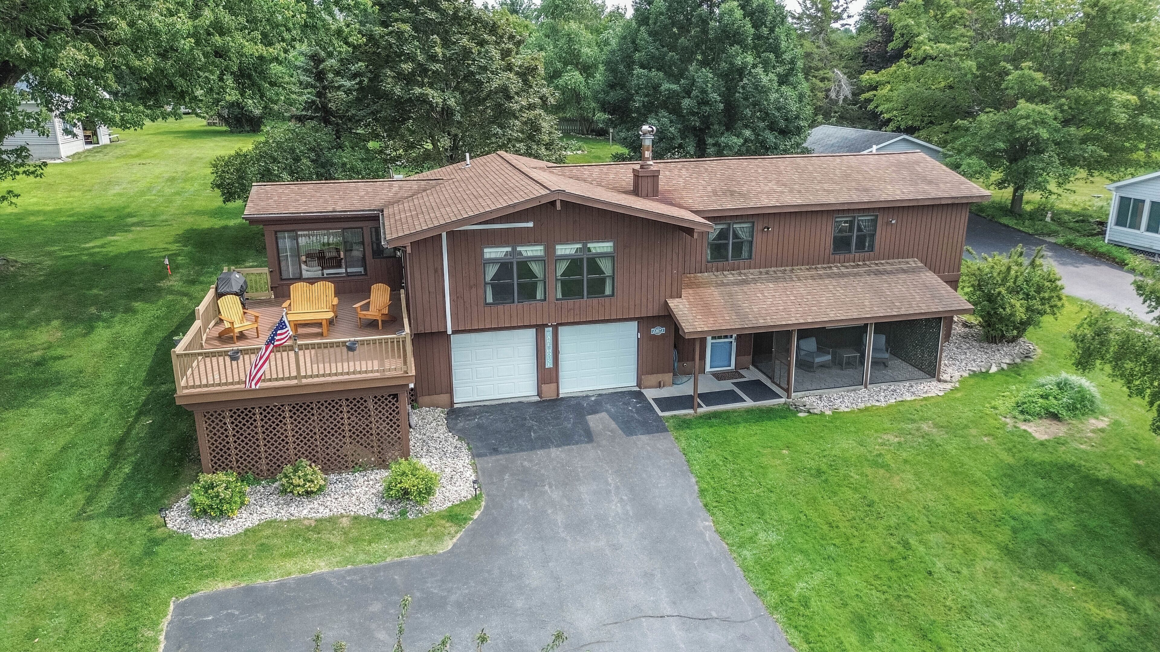 A two-story house with a covered porch, a garage, and a landscaped yard.