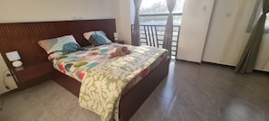 A hotel room with a bed, a nightstand, a lamp, and a view of the outdoors. - Luxury Villa in Ngaparou: 4 bedrooms, 5 bathrooms, pool, Wi-Fi, pool house (Ngaparou)