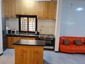 A modern kitchen with wooden cabinets, a gas stove, and a sink. - Luxury Villa in Ngaparou: 4 bedrooms, 5 bathrooms, pool, Wi-Fi, pool house (Ngaparou)