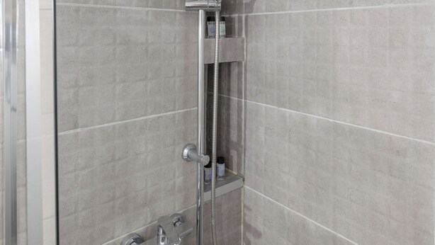A shower with a handheld showerhead, a wall-mounted faucet, and a handheld hose. - Athenian Apt with Balcony Pagkrati by GHH (Athina)