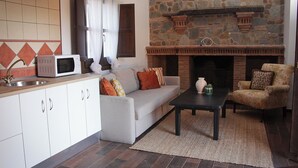 A modern kitchen with a stone fireplace, a grey sofa, and a coffee table.
