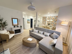 A modern living room with a sofa, coffee table, and a fireplace.