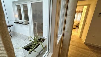 A modern interior with a sliding glass door leading to a kitchen area with a countertop and potted plants.