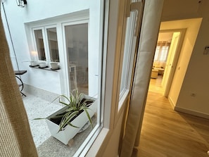 A modern interior with a sliding glass door leading to a kitchen area with a countertop and potted plants.