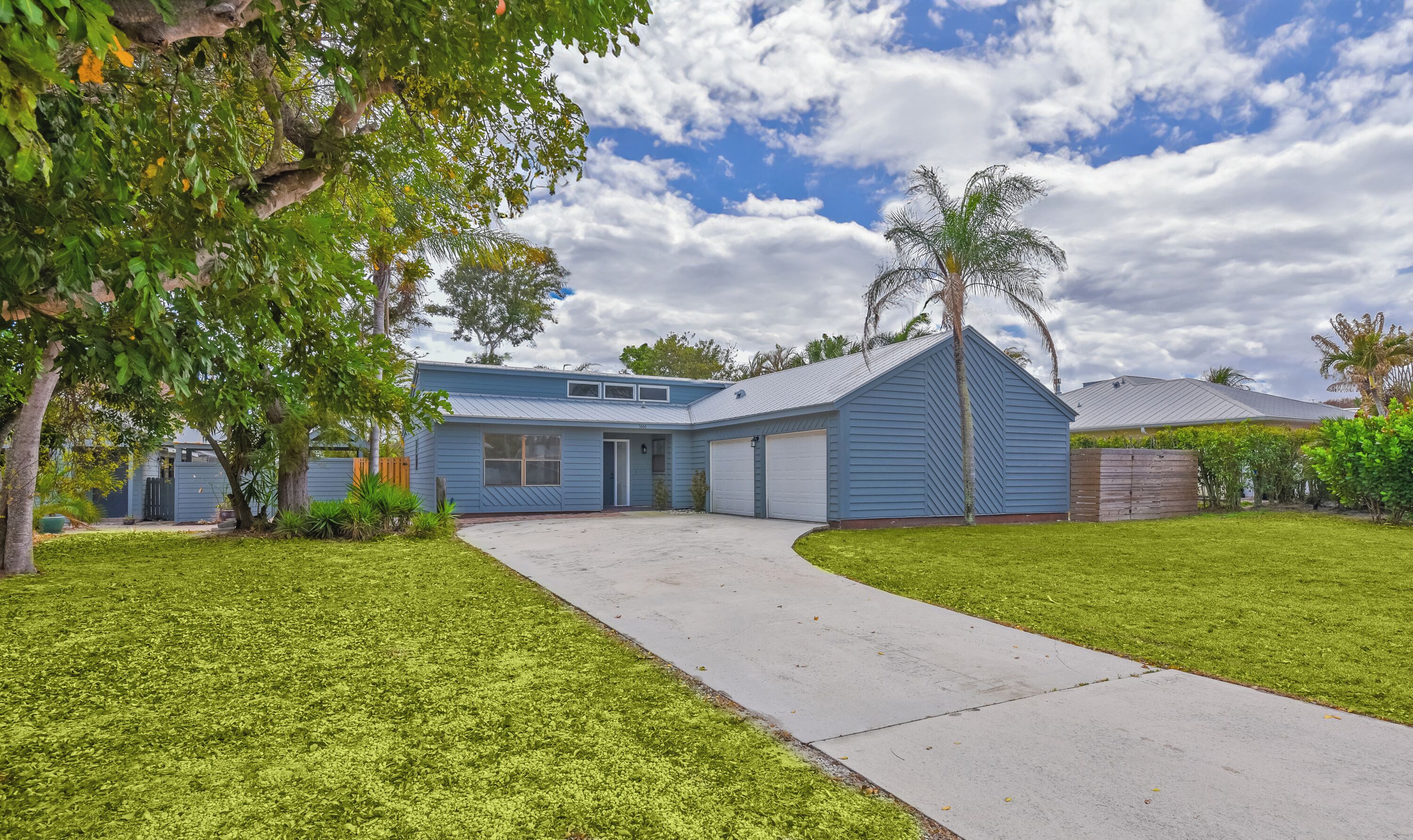 A residential house with a garage, a driveway, and a well-maintained lawn.