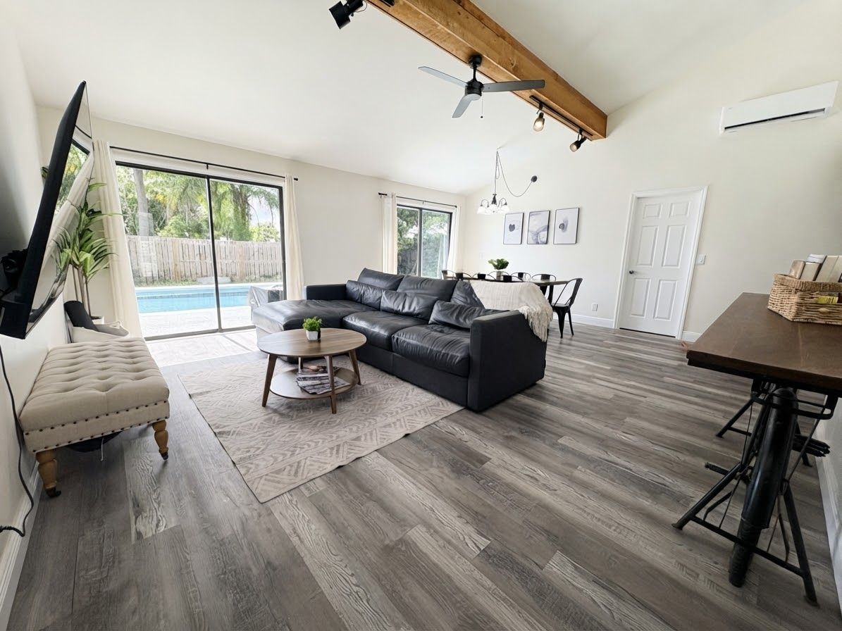 A spacious living room with a sectional sofa, a coffee table, and a dining area with a table and chairs.