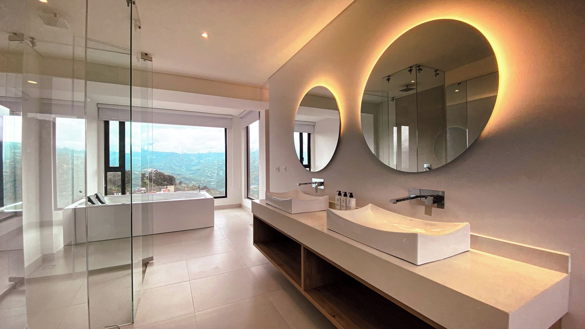 Un bagno moderno con un'ampia finestra, una vasca e due lavandini.
