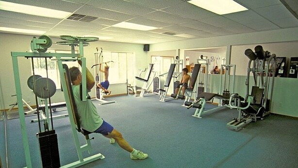 A gym with various exercise equipment, including weight machines and free weights.