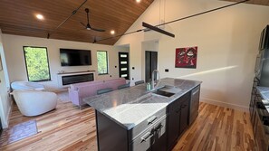 A modern kitchen with a granite countertop, stainless steel appliances, and a built-in oven. - The Loft at Acadia Gateway (Trenton)
