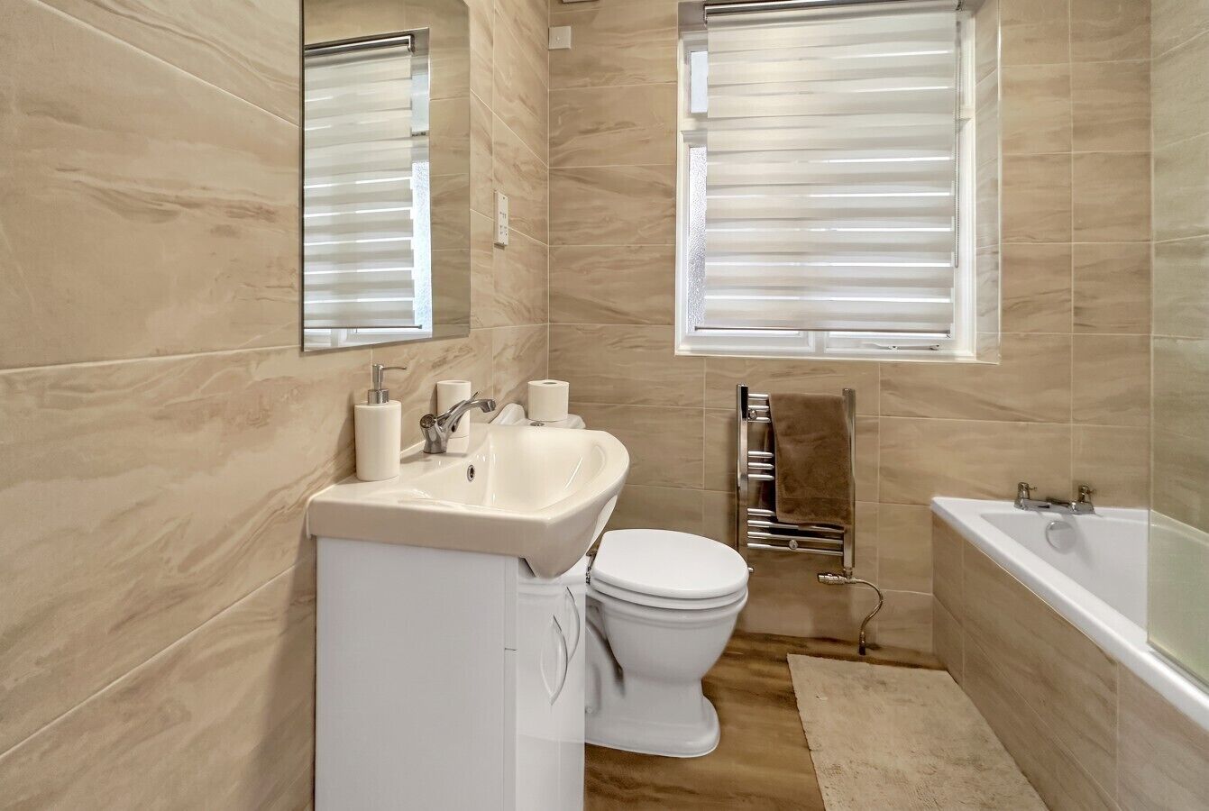 A modern bathroom with a sink, toilet, and bathtub.