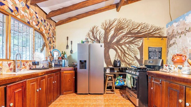 Una cocina con armarios de madera, un refrigerador, un microondas y una estufa.