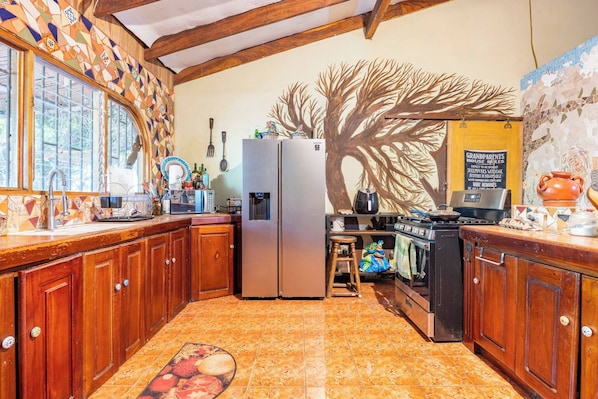 A kitchen with wooden cabinets, a refrigerator, a microwave, and a stove.