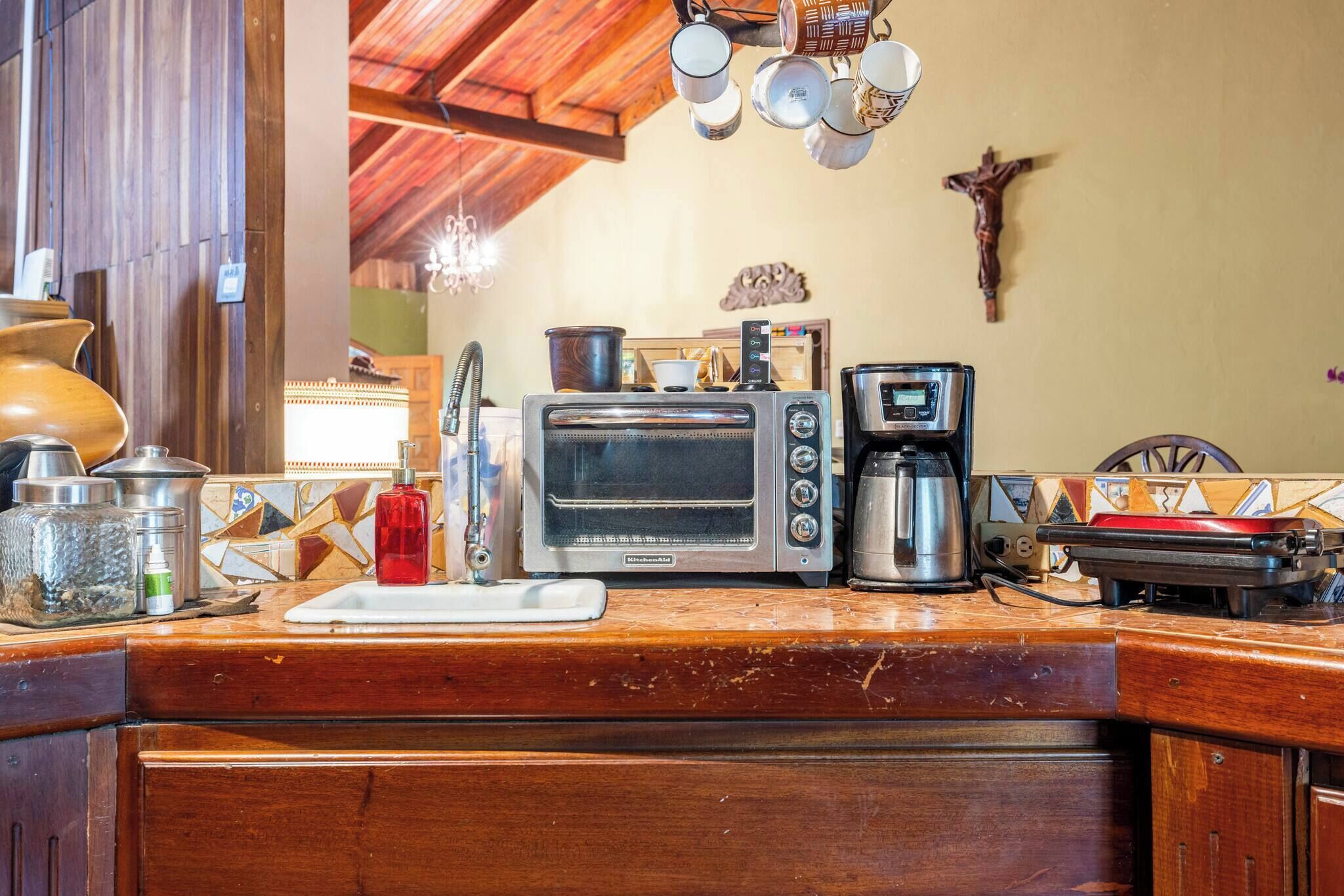 A kitchen with a built-in toaster oven, coffee maker, and a wooden countertop.