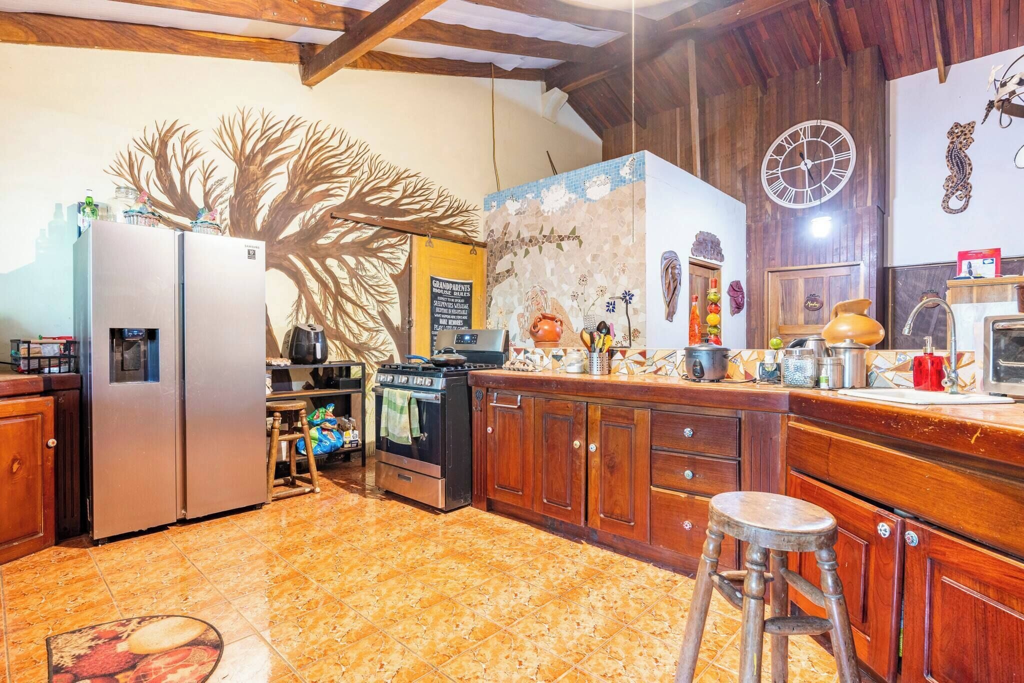 A kitchen with a refrigerator, stove, and wooden cabinets.