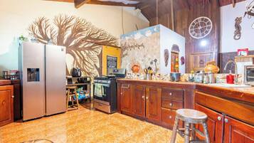 A kitchen with a refrigerator, stove, and wooden cabinets.