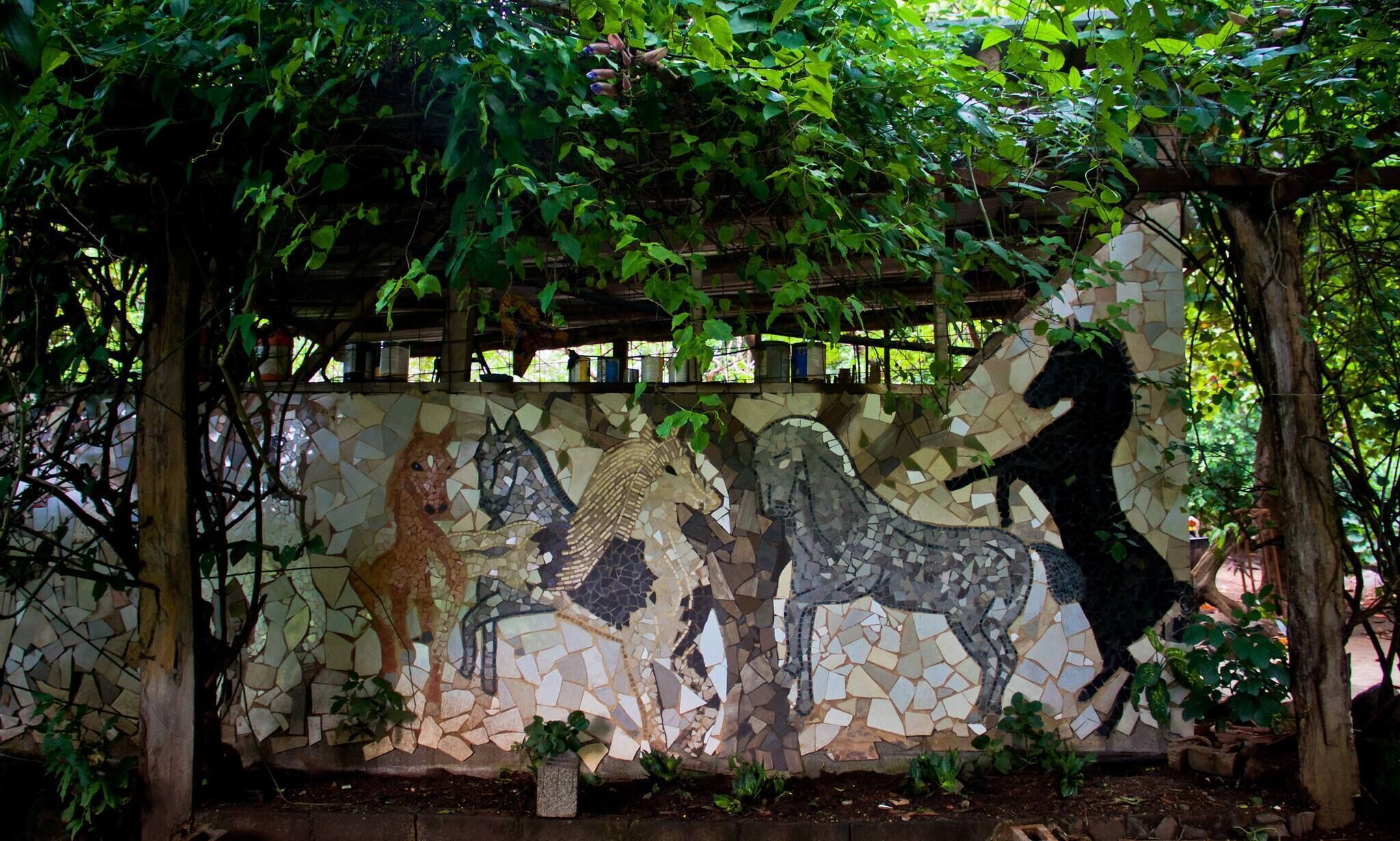 Een mozaïekwand met afbeeldingen van paarden.
